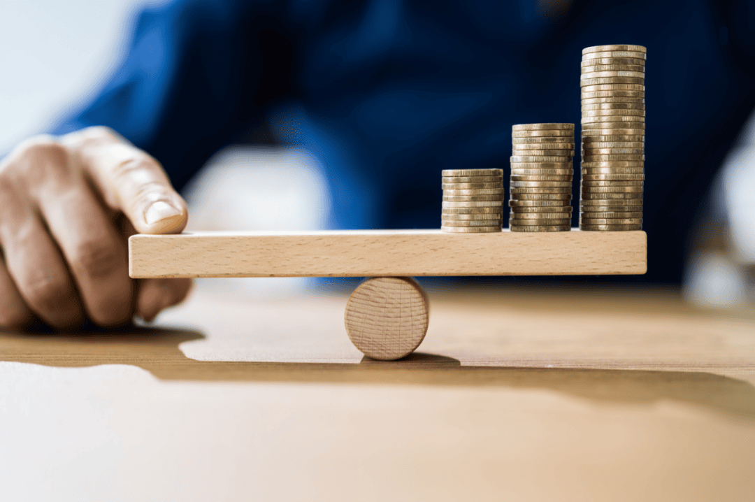 Business Man measuring the weight of  coins on a  wooden scale for balance